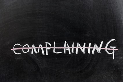 Word "Complaining" On a Chalkboard Crossed out