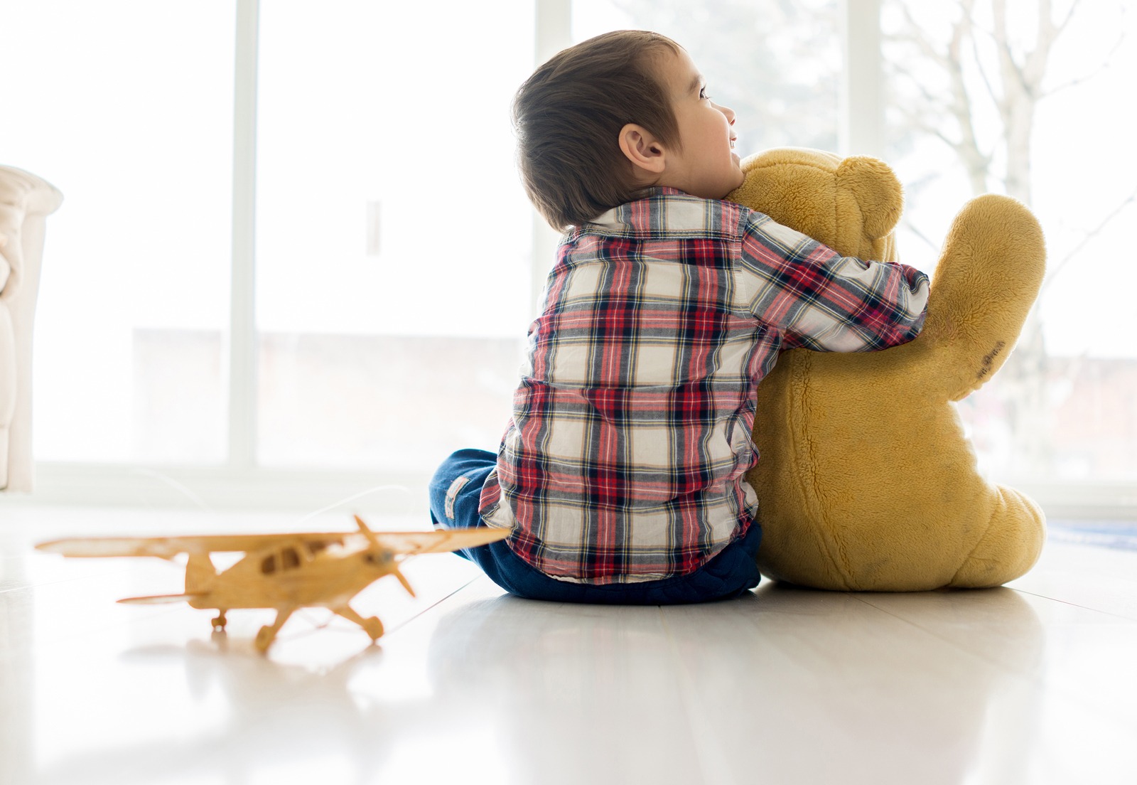 Child sitting in living room with Teddy bear