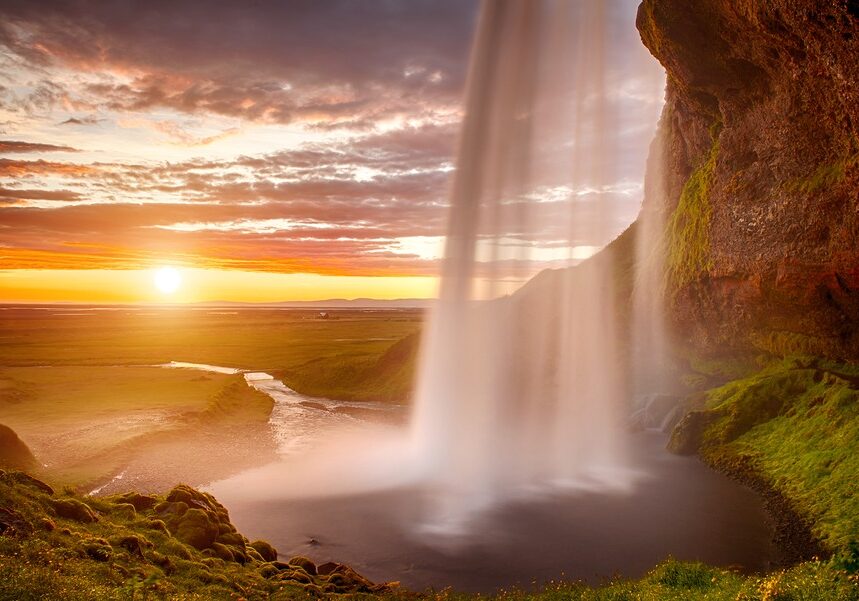 Large Waterfall With River Flowing Away Towards Sunset